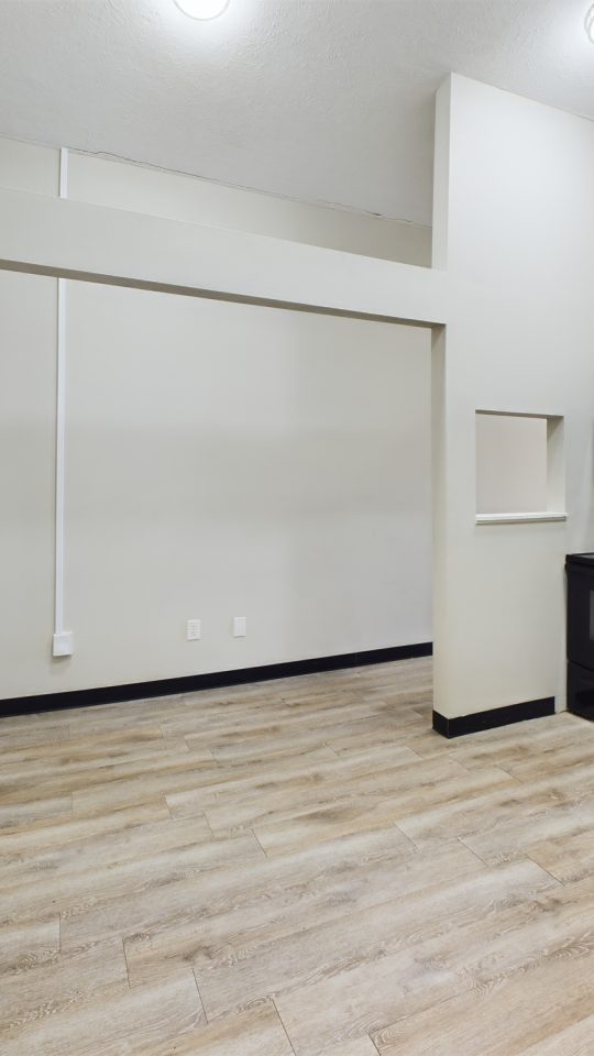 a kitchen with white cabinets and black appliances at The Kensington Apartments