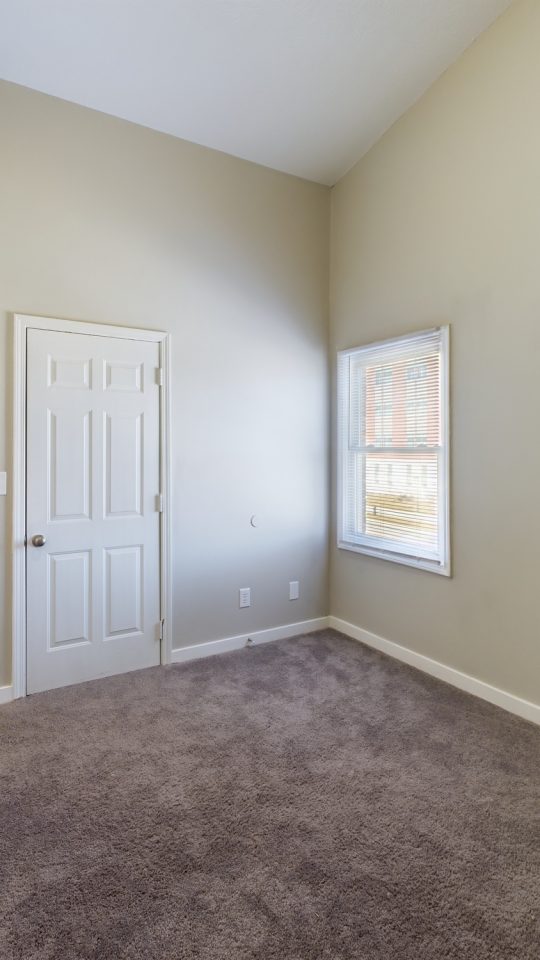 empty room with carpet and door at The Kensington Apartments