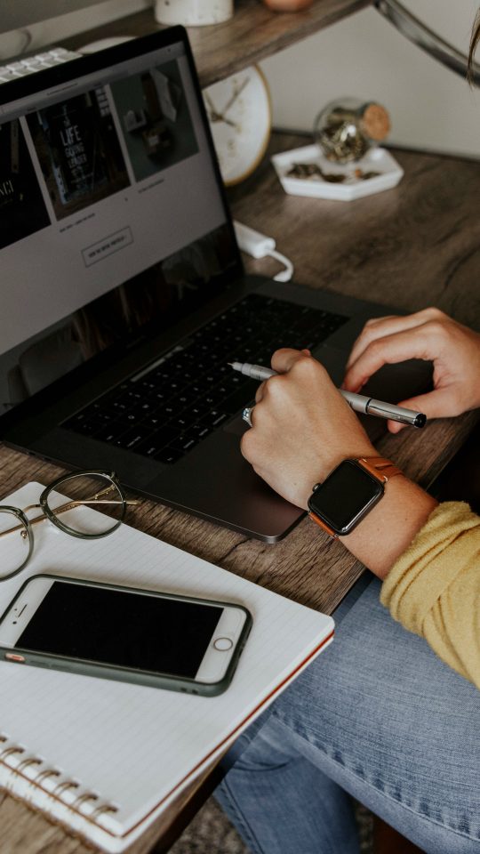 person in blue denim jeans using macbook pro